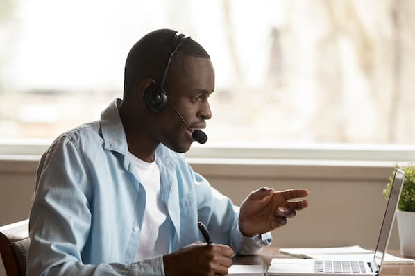 Sales support agent on a call at an open plan desk